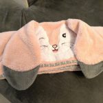 cape de bain lapin bélier rose et gris sur canapé